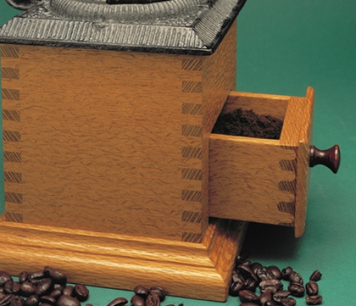 Closeup of Coffee Grinder in lacewood with square finger joints and rounded half-blind finger joints on drawer. 10 1/4"H x 6 1/2"W x 6 1/2"D