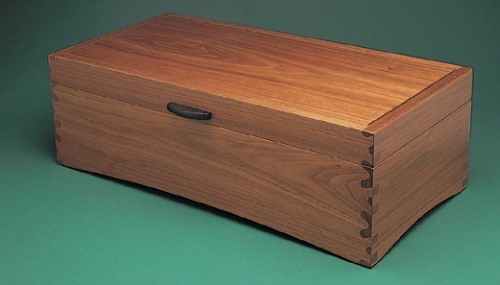 Storage Box in American black walnut with through Isoloc Bears Ears joint pattern. Handle in ebony. 5 1/2H x 16W x 8D